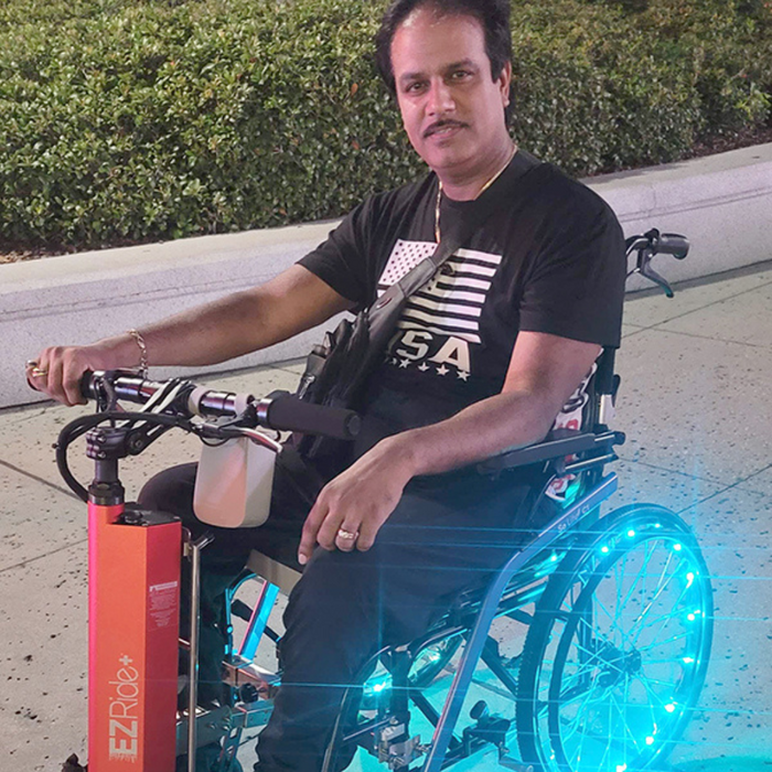 PersonOnEZRide_WheelchairAttachmentEnjoyingGoingDownTheStreet
