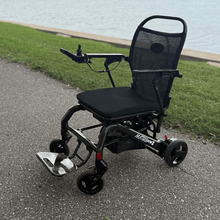 Matrix Ultra 2 Wheelchair  on a paved path with grass and water in the top angle babackground