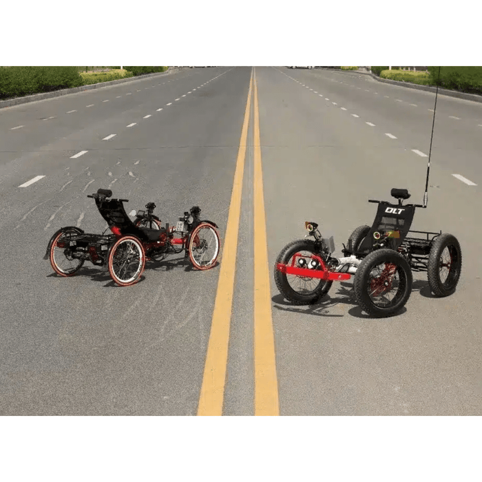 recumbent quad on a rack, surrounded by other trikes.
Two electric fat tire recumbent quads on a deserted road, viewed from the front, showcasing their large tires and high ground clearance.