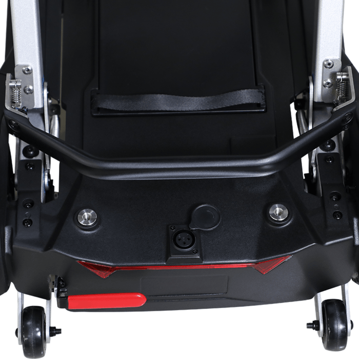 Close-up rear view of the folded MobiFree scooter base showing the carry handle, charging port, red reflectors and rear wheels