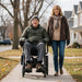 Senior couple enjoying a walk together with man on Journey Air Elite Max power chair