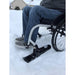 Slick Skis Caster Attachment attaching to Wheelchair on Snowy Surface