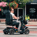 Pride PX4 4-Wheel Scooter Riding on side walk