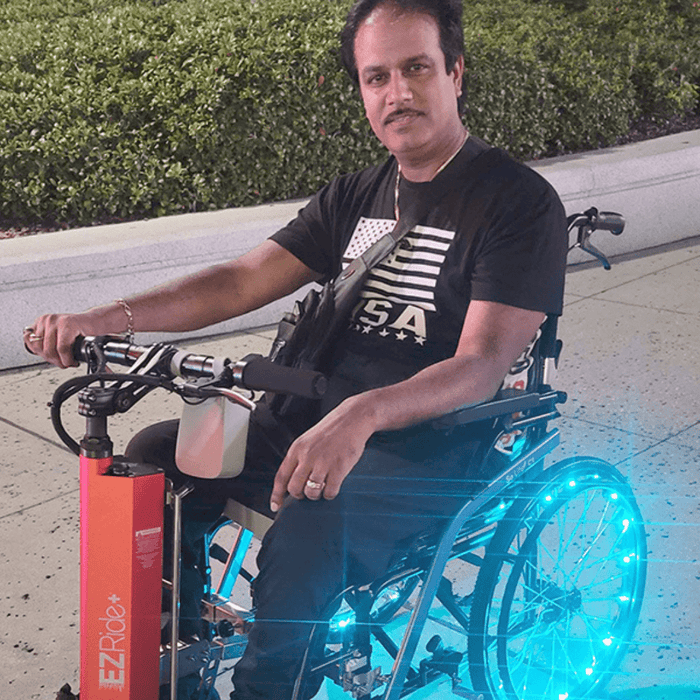 PersonOnEZRide_WheelchairAttachmentEnjoyingGoingDownTheStreet